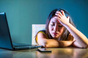 Woman sits frustrated from cyber-stalking her ex. You may be mad at your ex, but don't be an exhole.
