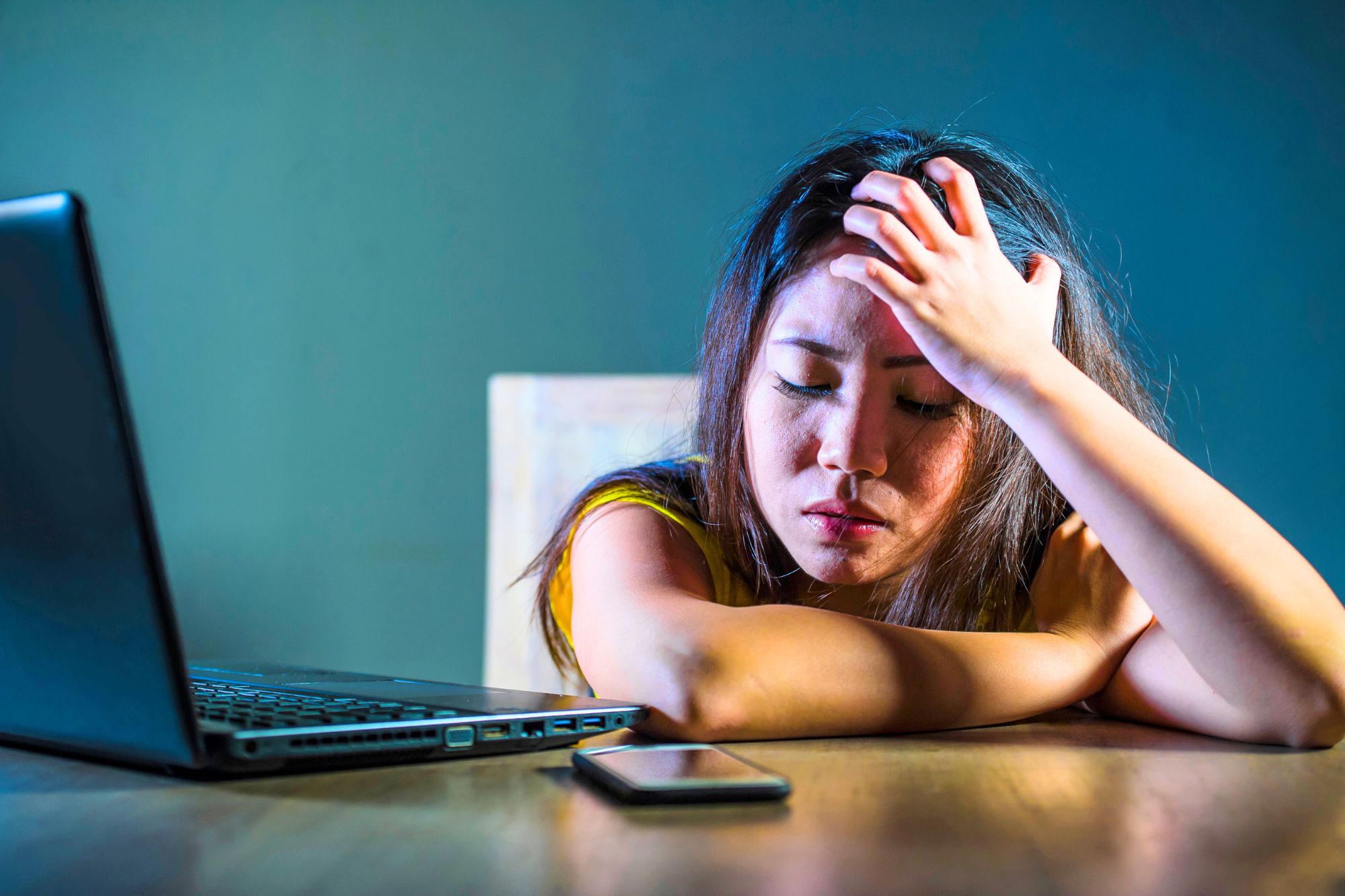 Woman sits frustrated from cyber-stalking her ex. You may be mad at your ex, but don't be an exhole.