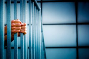 Close up on the hands of a person who feels like a prisoner of an unhappy marriage gripping what looks like jail cell bars.