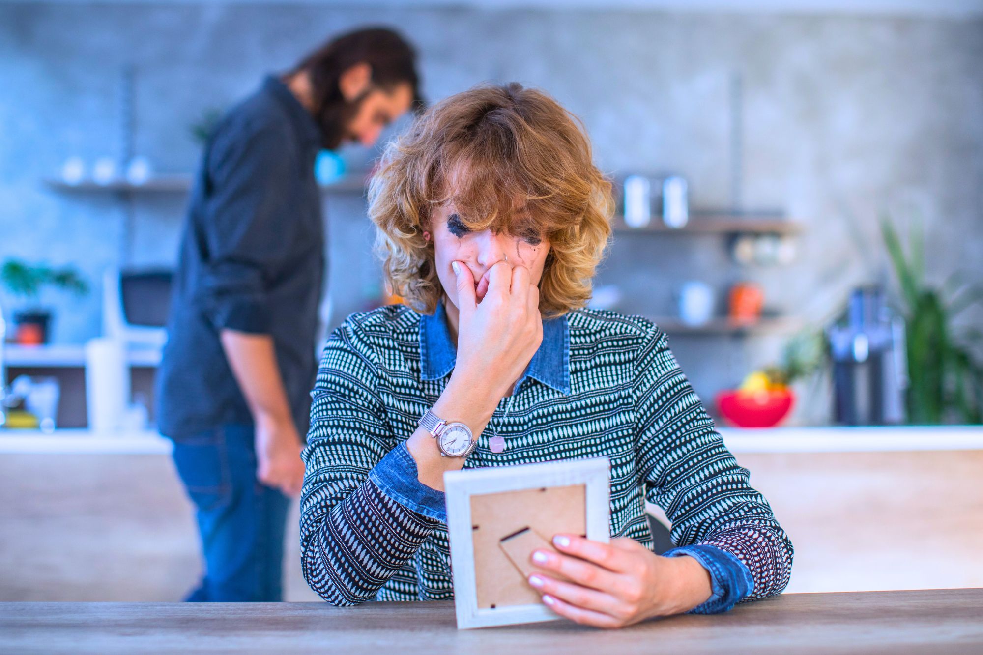 Women cries while husband paces in background- they are contemplating if they are doomed to a marriage of unhappily ever after.