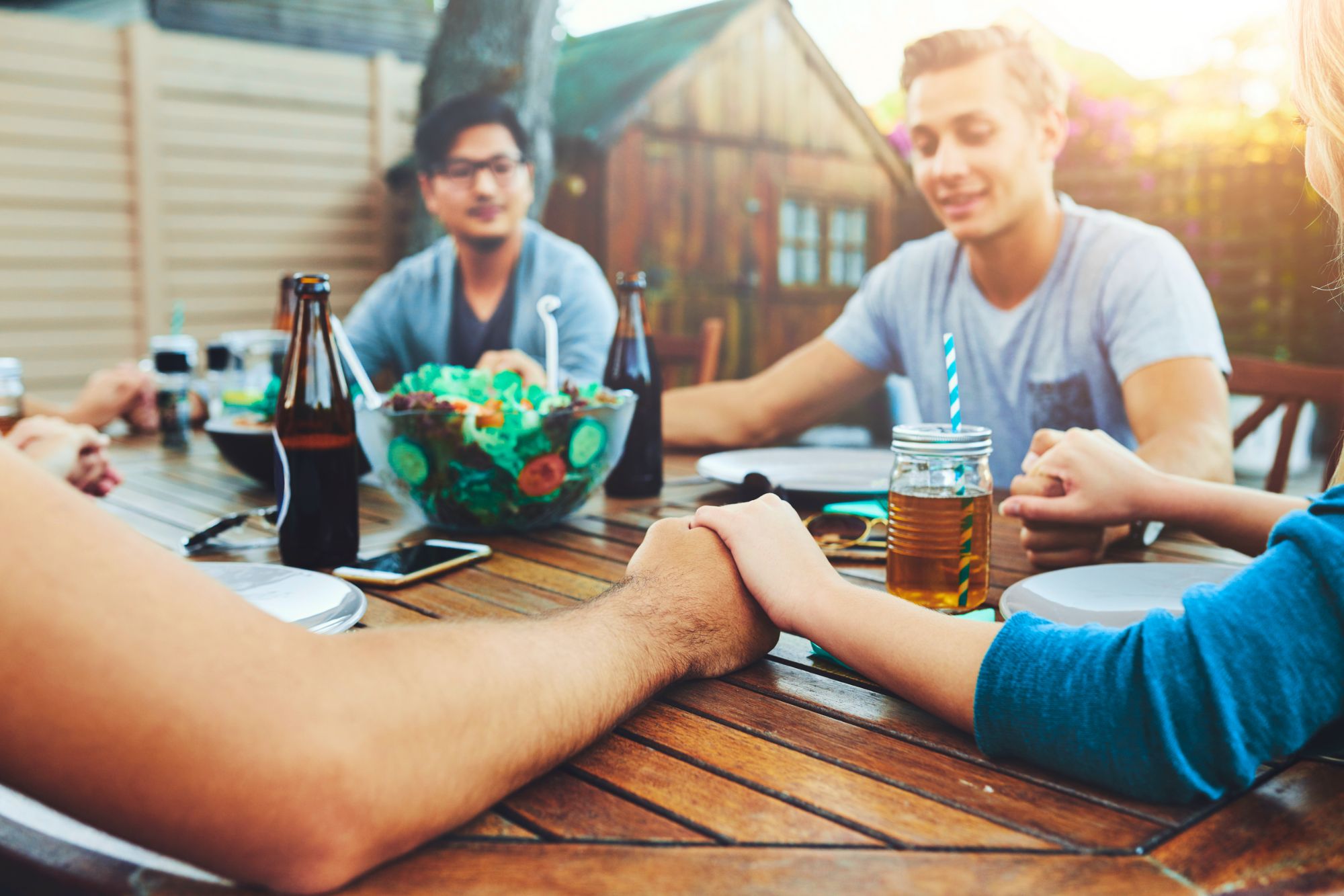 Friends sitting around the dinner table discussing the tips for taking the horrible out of the holidays.