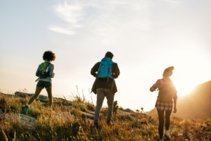 Silhouette of 3 friends, hiking up a rise toward a sunset/rise. 5 Things you HAVE to do to FINALLY get over your breakup.
