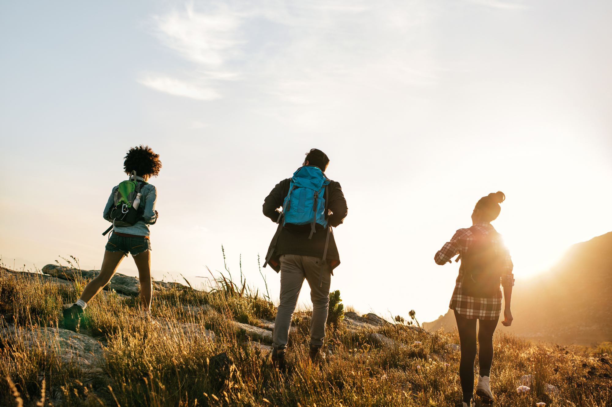 Silhouette of 3 friends, hiking up a rise toward a sunset/rise. 5 Things you HAVE to do to FINALLY get over your breakup.