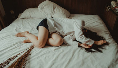 Woman lying on a bed struggling with overcoming divorce grief. Woman lying on a bed struggling with overcoming divorce grief.