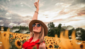 Happy woman in a field of sunflowers celebrating successfully rebuilding a life after divorce.