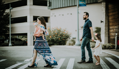 Family walking across the street yet one of these parents is miserable in their marriage.