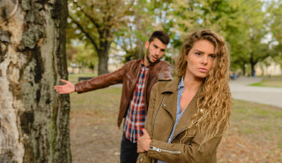 Couple near a tree arguing about how to handle co-parenting. Couple near a tree arguing about how to handle co-parenting.