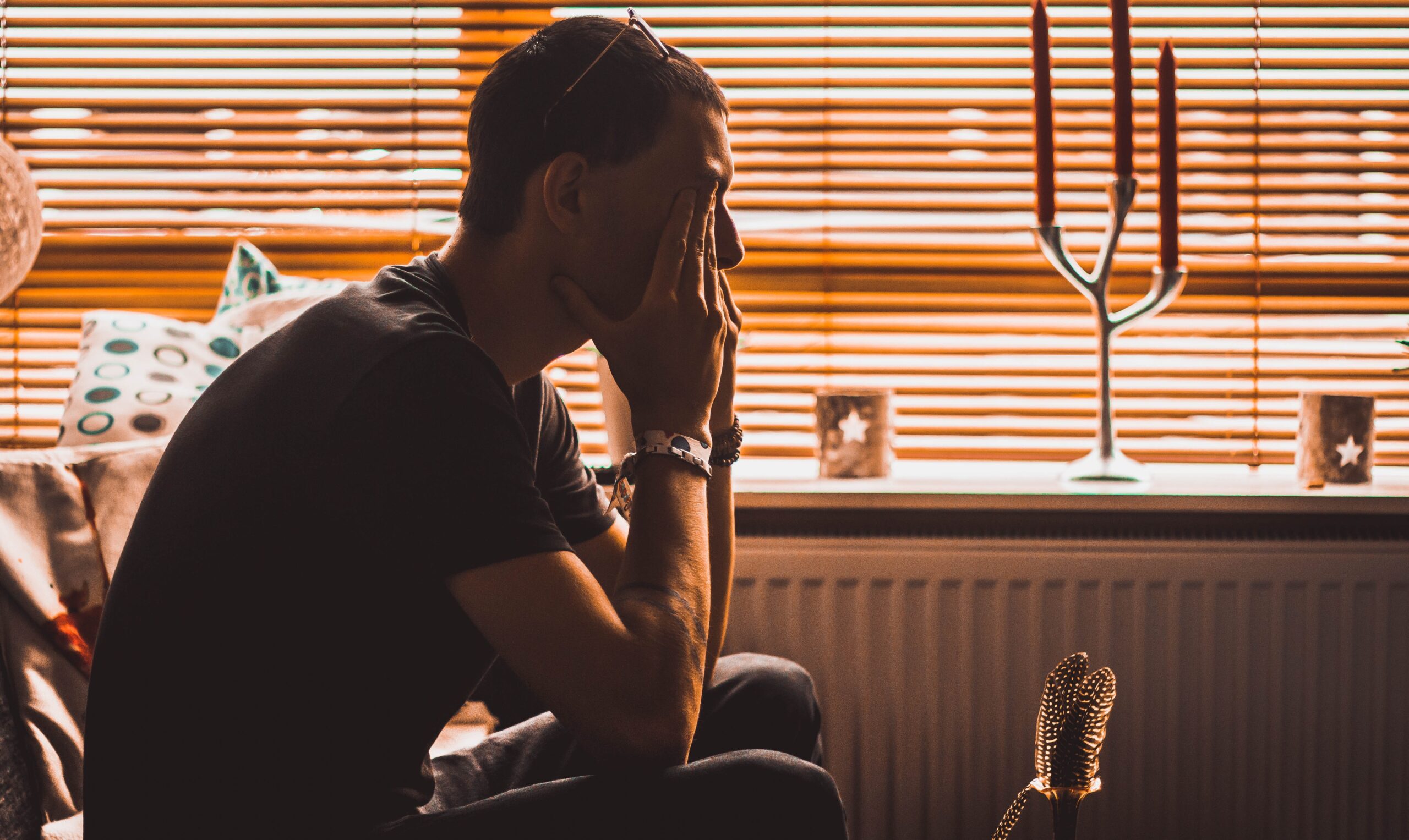 struggling-with-life-after-divorce Man sitting with his hands covering his eyes as he struggles with life after divorce.