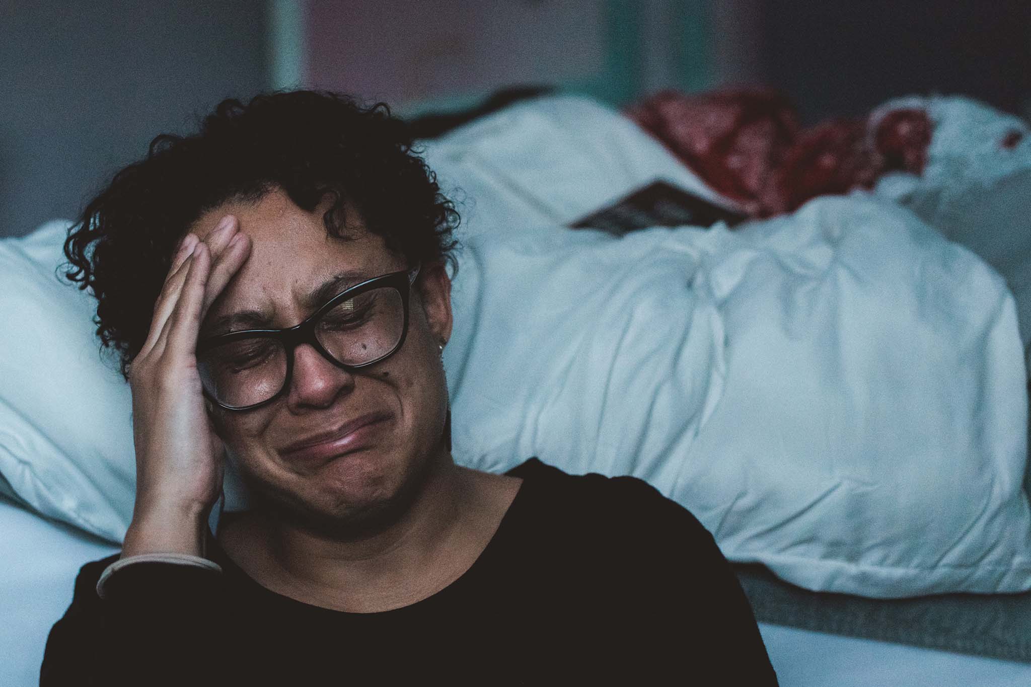 2021-blog-how-to-improve-a-miserable-marriage Woman sitting on the floor next to her bed crying about her miserable marriage